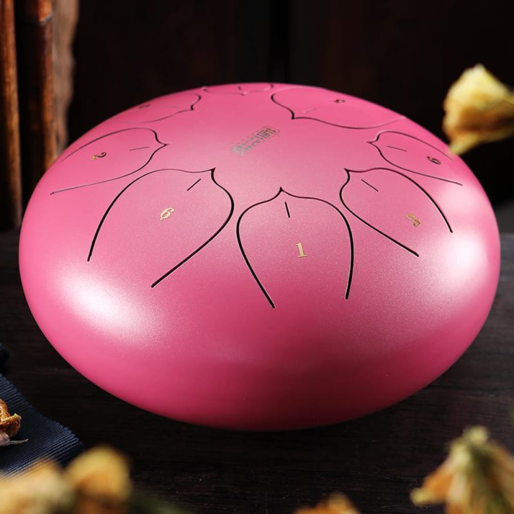 Pink steel tongue drum with etched tone markings for portable music in C key