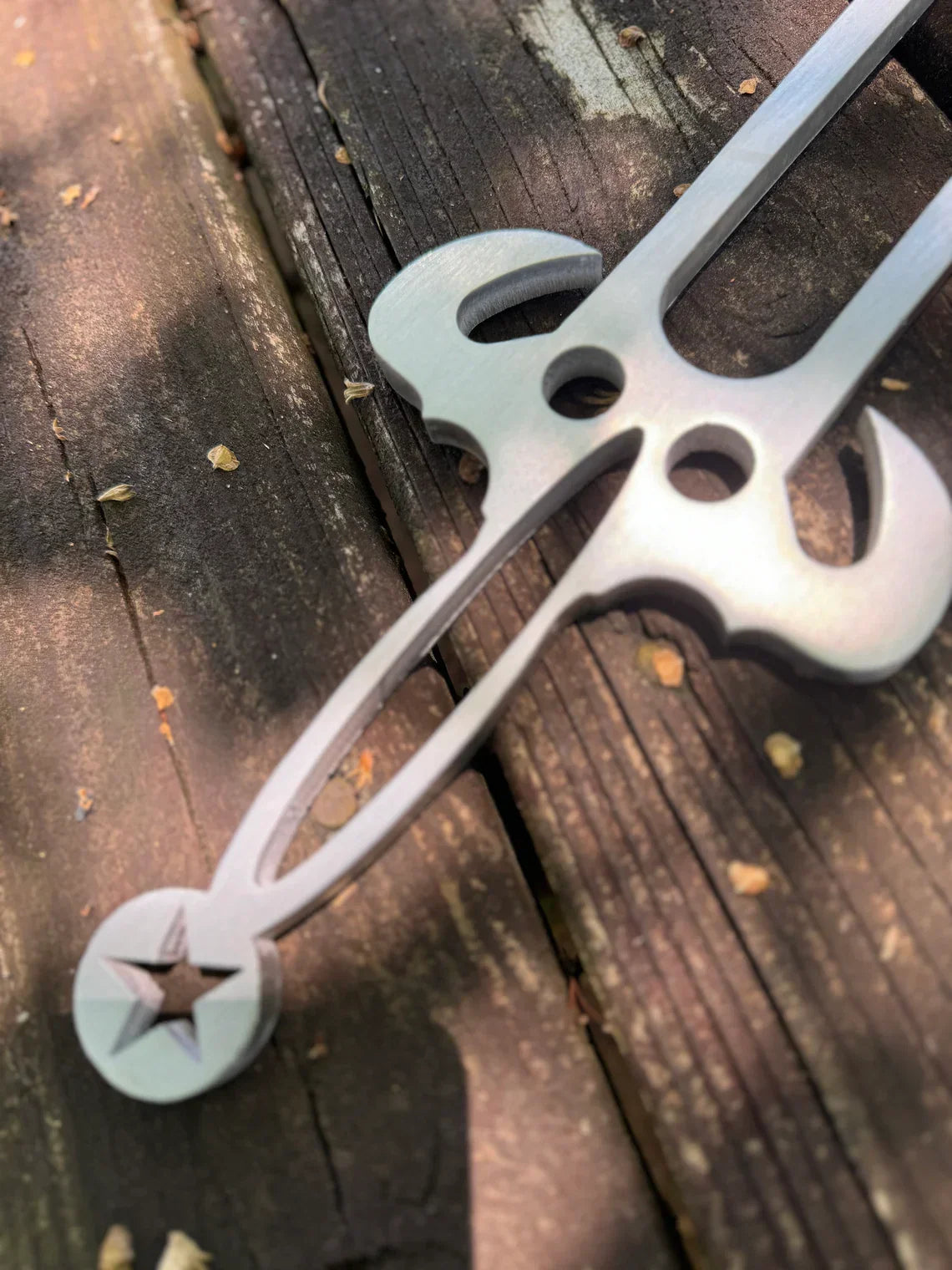 Metal tuning fork utensil with decorative holes and star pattern tip in 128Hz Trident design