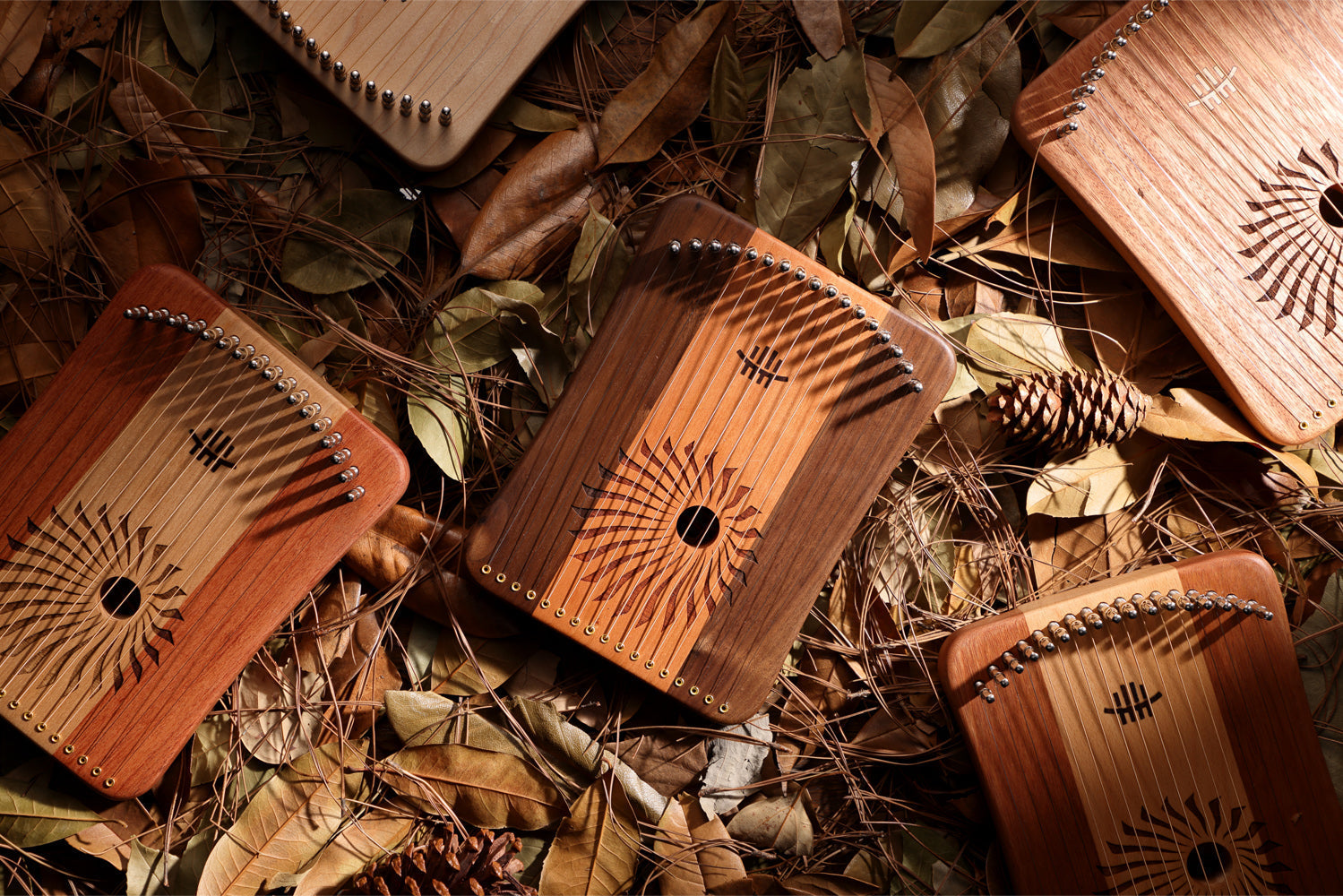 Wooden Kalimbas with decorative sunburst patterns from Hluru’s 17/31 String Lyre Harp