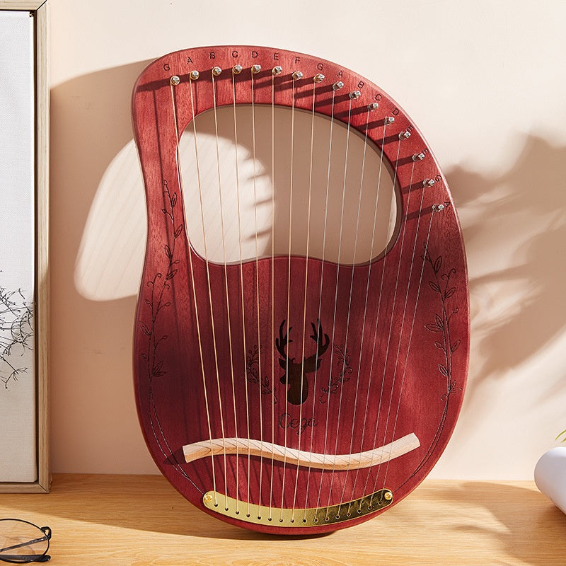 Red wooden lyre harp with metal strings and a curved design for the Mahogany Lyre Harp