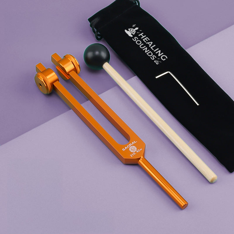 Orange tuning fork with adjustable resonance weights for 210.42 Hz Sacral Chakra healing