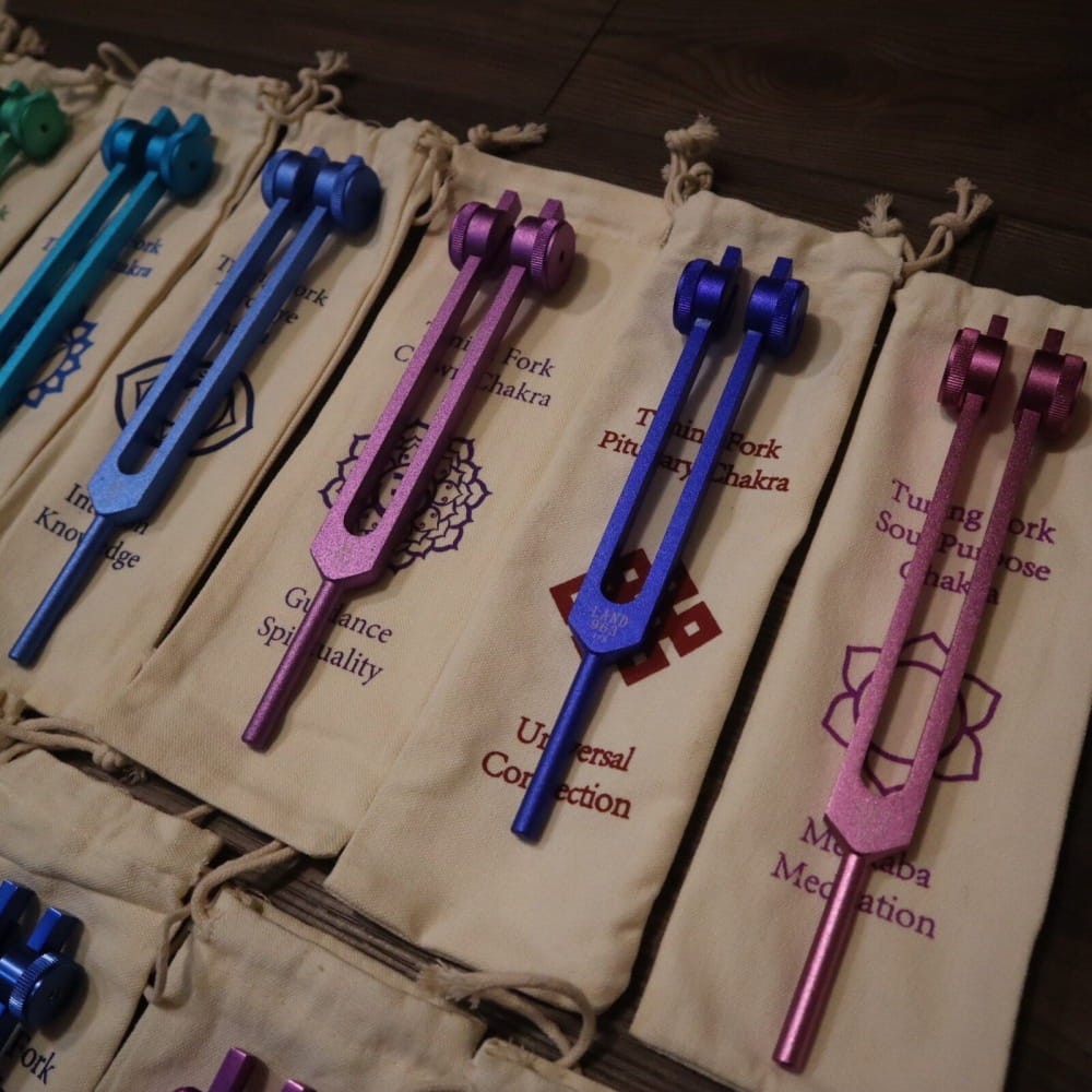 Colorful tuning forks with chakra symbols in fabric pouches for Solfeggio set
