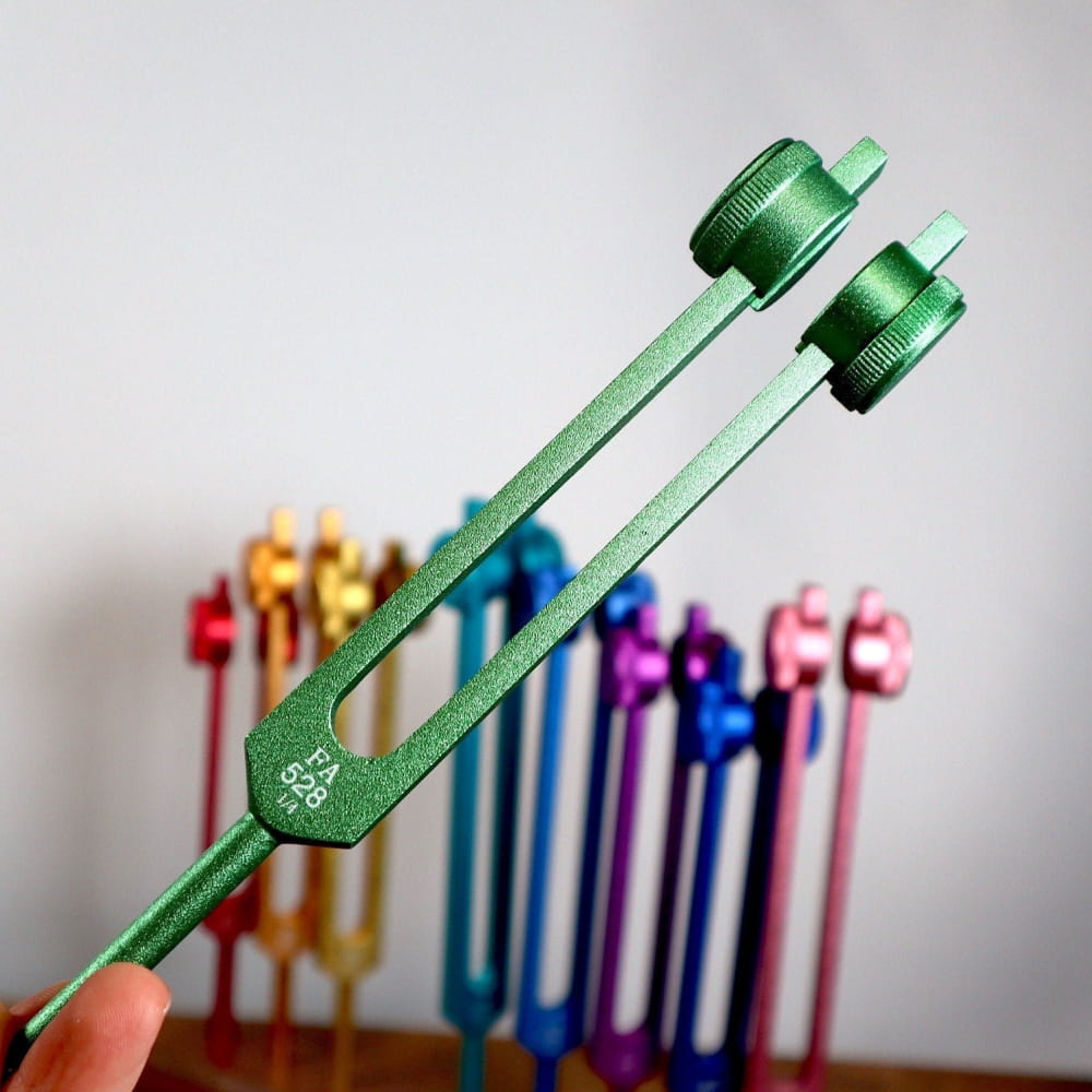 Green metal tuning fork with two prongs for 528 Hz healing and chakra therapy