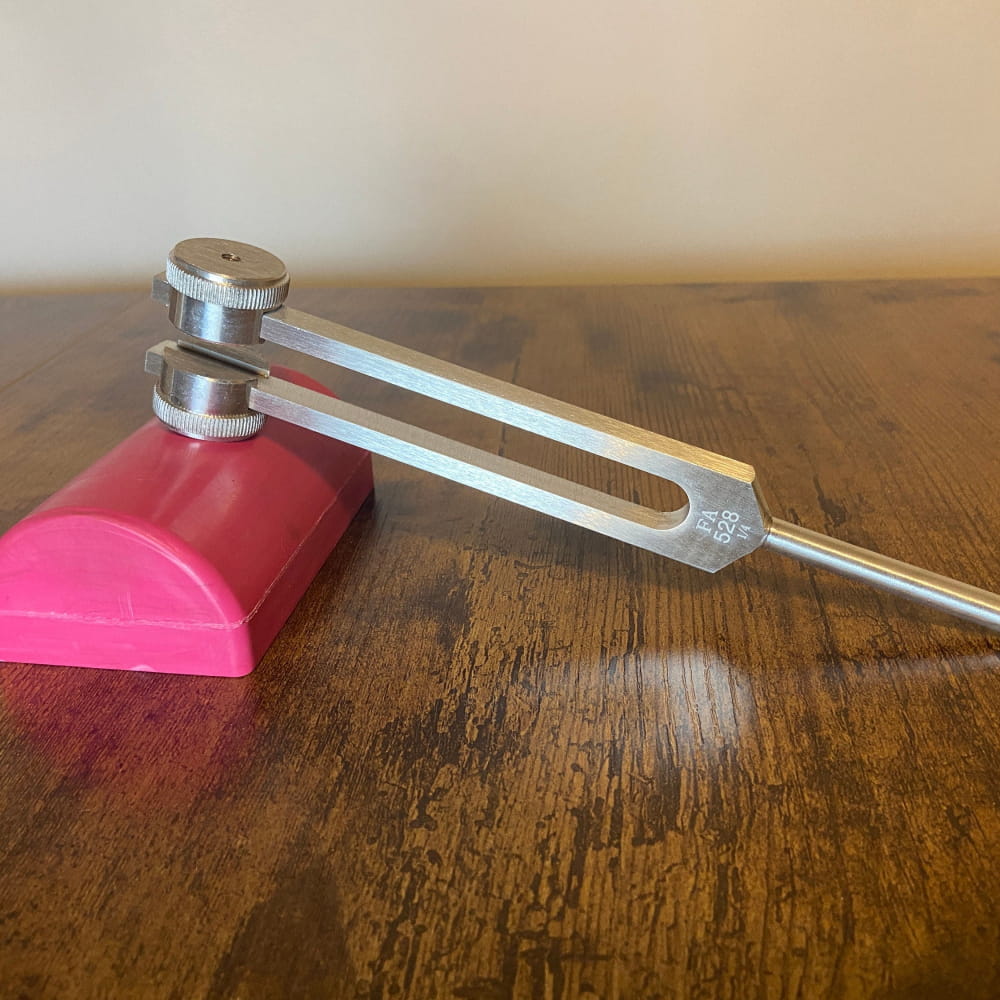 Medical reflex hammer with pink rubber head and metal handle for healing therapy