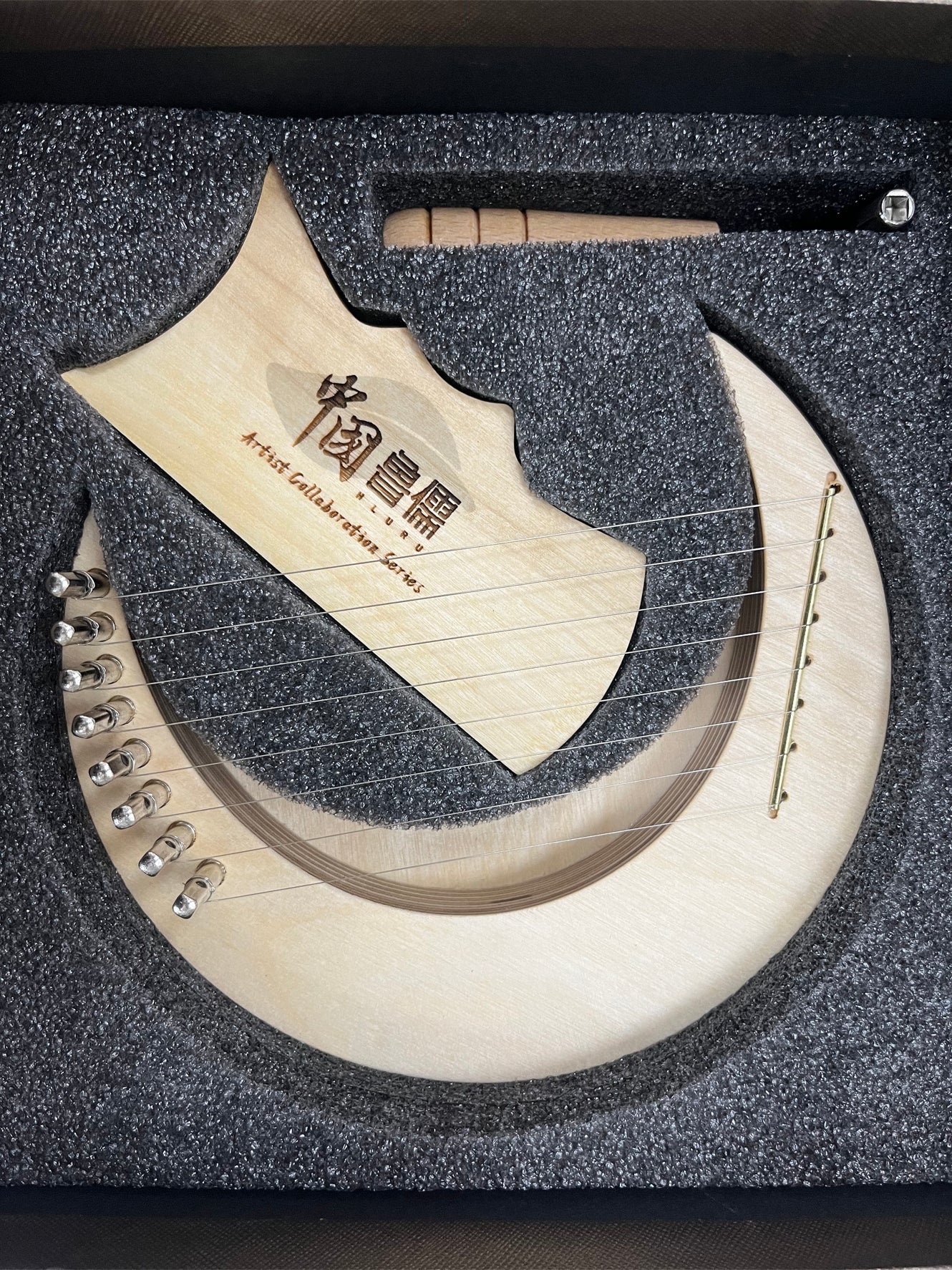 Curved bone-colored blade of 8-String Mini Lyre Harp with Chinese characters and notches
