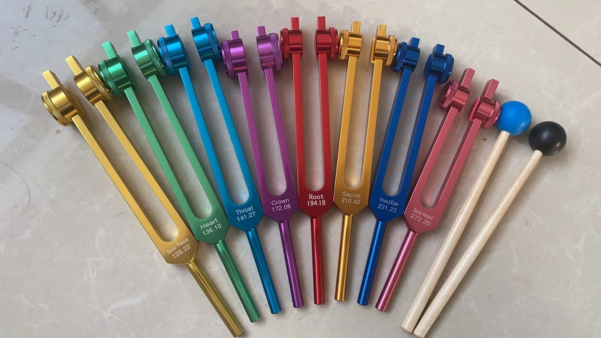 Colorful tuning forks in a fan pattern from 8pc Chakra Healing Tuning Fork Set