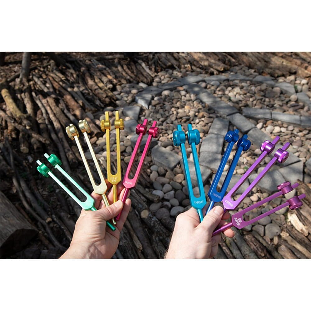Colorful tuning forks in hands from 8pc Chakra Healing Tuning Fork Set with Stand & Activator