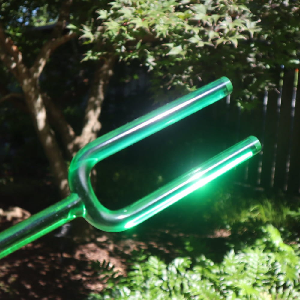Glowing green neon trident in Crystal Tuning Fork Set for CDEFGABC5 notes