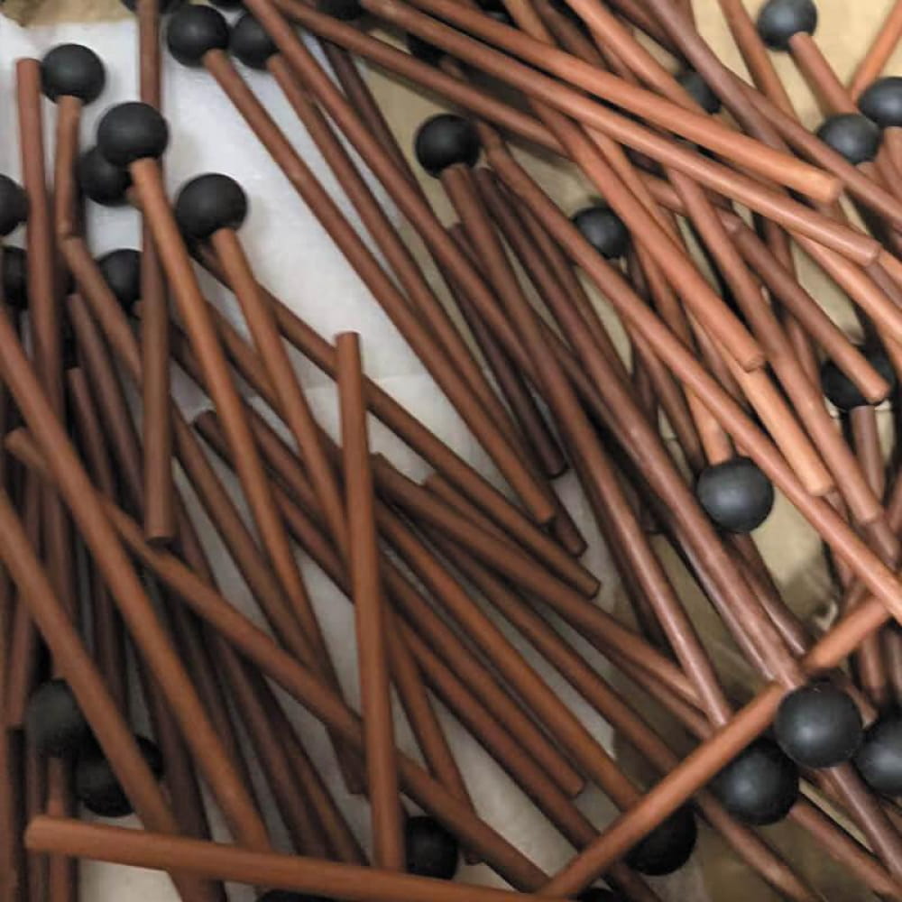 Collection of brown wooden matches with black tips scattered around Premium Wooden Drumsticks