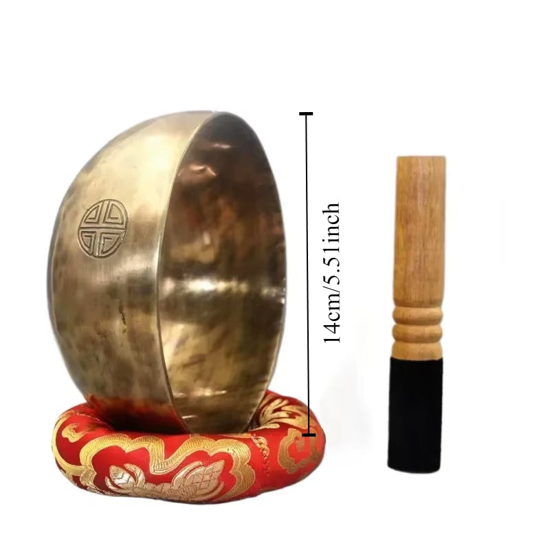 Tibetan Singing Bowl with wooden striker on a decorative red cushion for meditation healing
