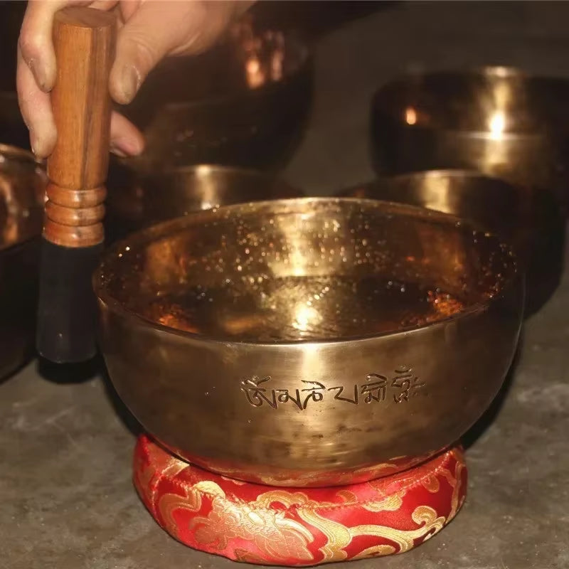 Tibetan Singing Bowl on a red and gold cushion for meditation and healing