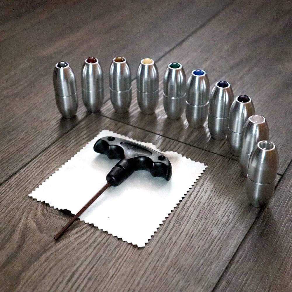 Black earbuds in a cross shape on a white napkin with metallic bullet objects