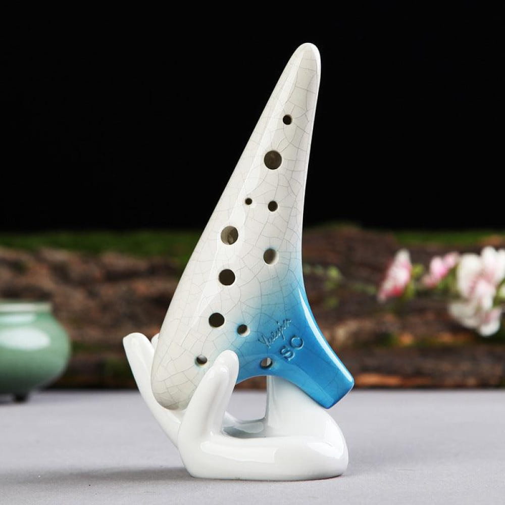 White ceramic 12 Hole Soprano Ocarina with blue accents and finger holes