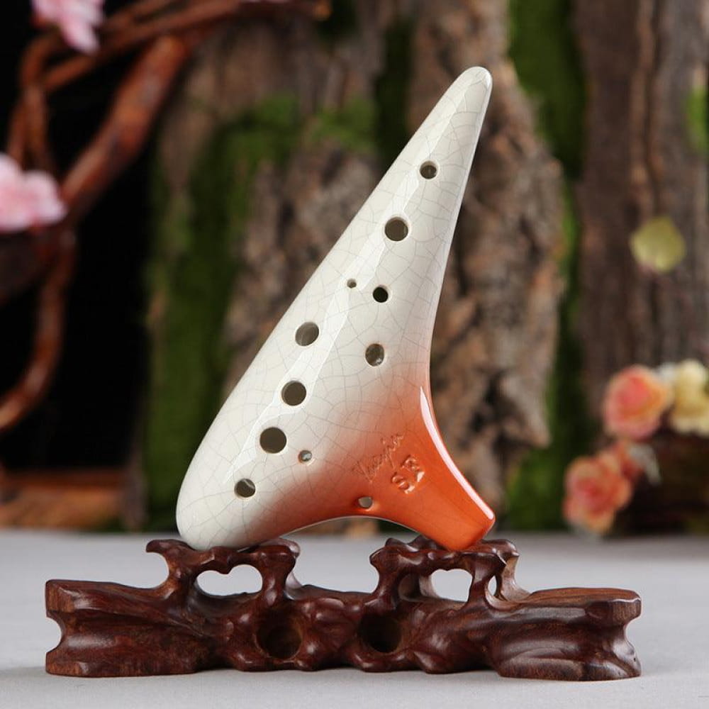 White and orange ceramic 12 Hole Soprano Treble Ocarina on a decorative brown stand