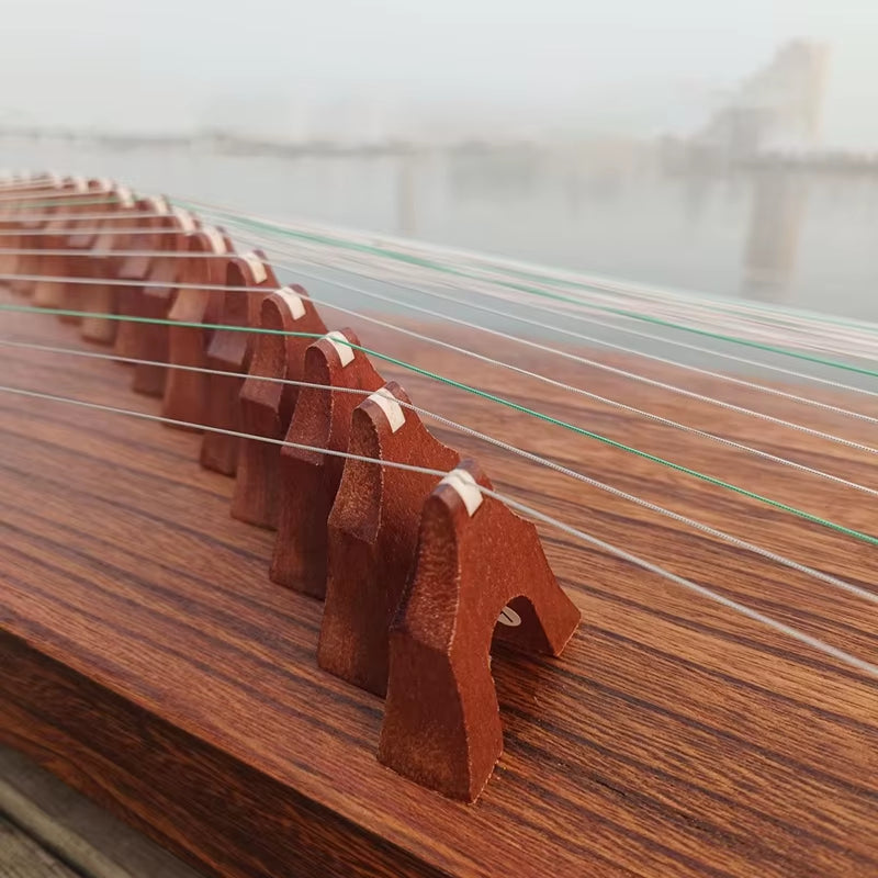 Row of wooden bridges supporting strings on a Portable Paulownia Wood Guzheng Zither