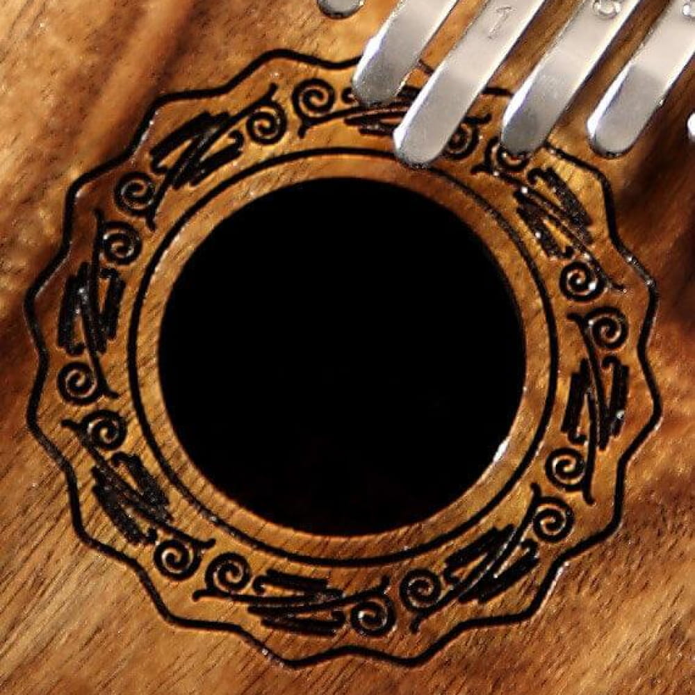 Ornate wooden frame with swirling patterns around 17 Key Acacia Kalimba Thumb Piano