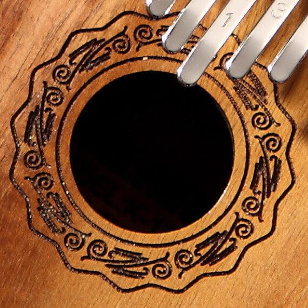 Decorative sound hole of a guitar with ornate patterns in 17 Key Acacia Thumb Piano