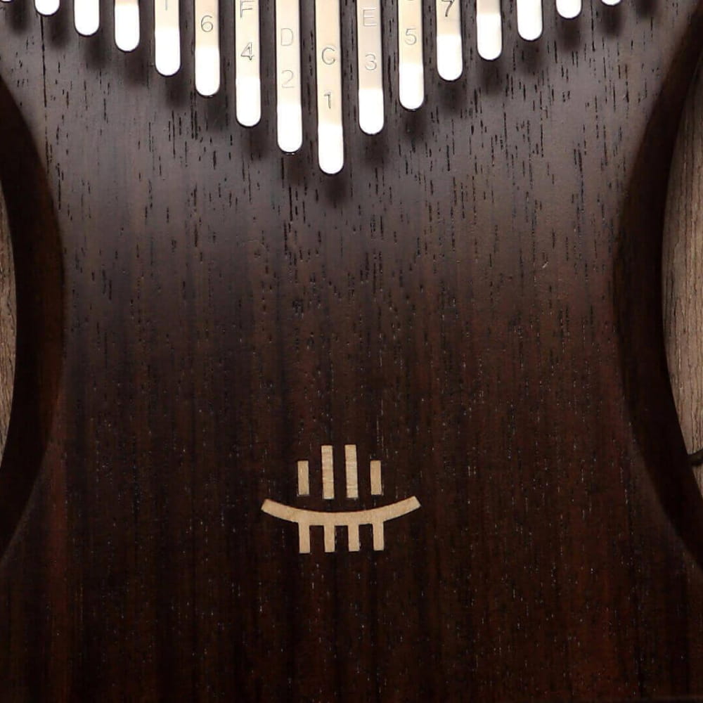 Kalimba with white tines in V-shape on dark wood for meditation and relaxation