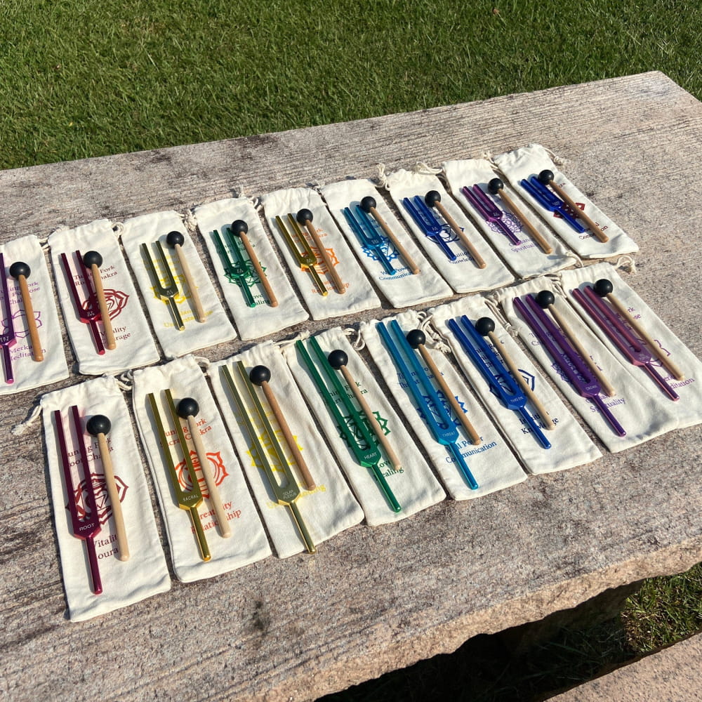 Colorful recorders arranged on white cloths for the Solfeggio Chakra Tuning Fork Set