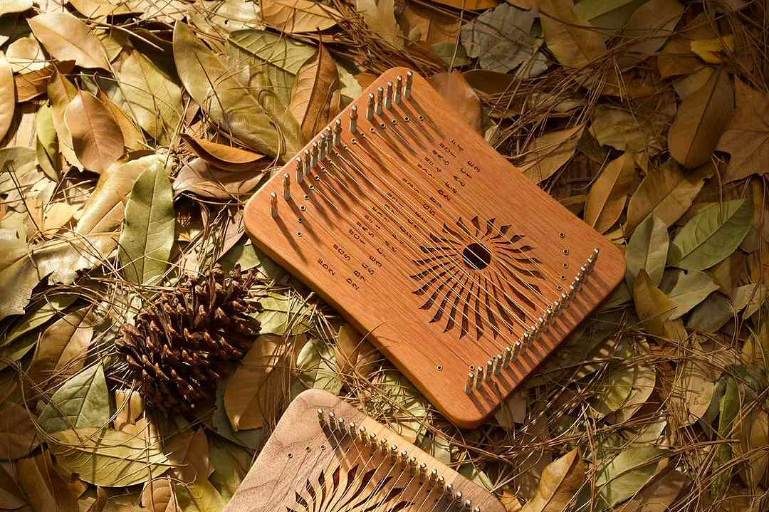 Terracotta kalimba with sunburst design from 17 String Rosewood Lyre Harp by Hluru