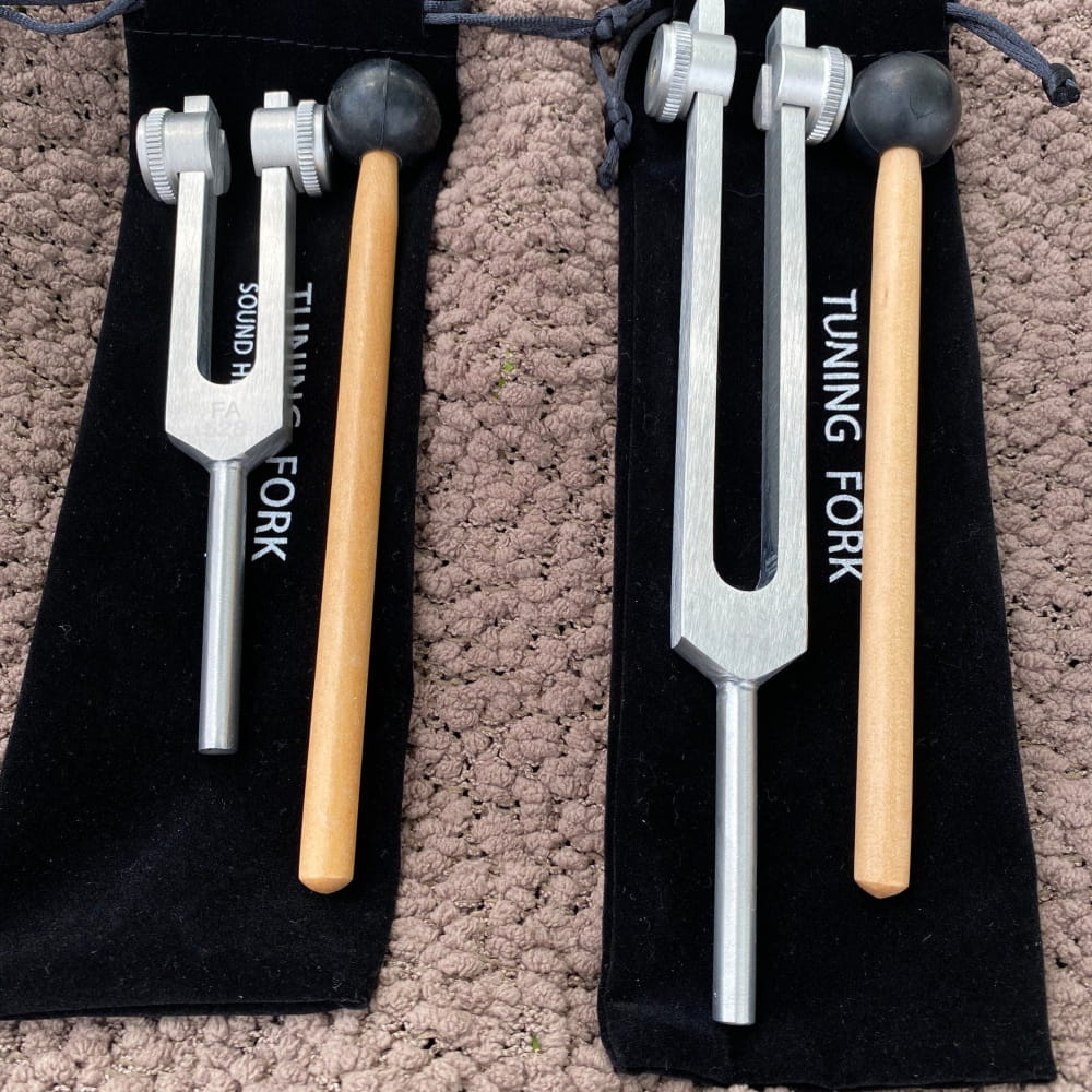 Two 174 Hz and 528 Hz Healing Tuning Forks with Crystal Handle on black fabric