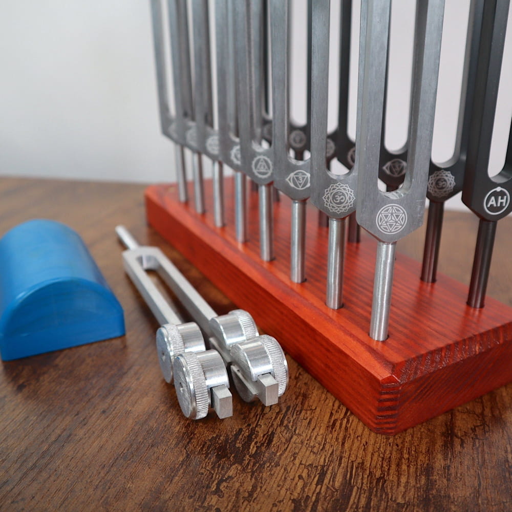 Set of tuning forks in a red holder with metal strikers for Chakra and Solfeggio frequencies