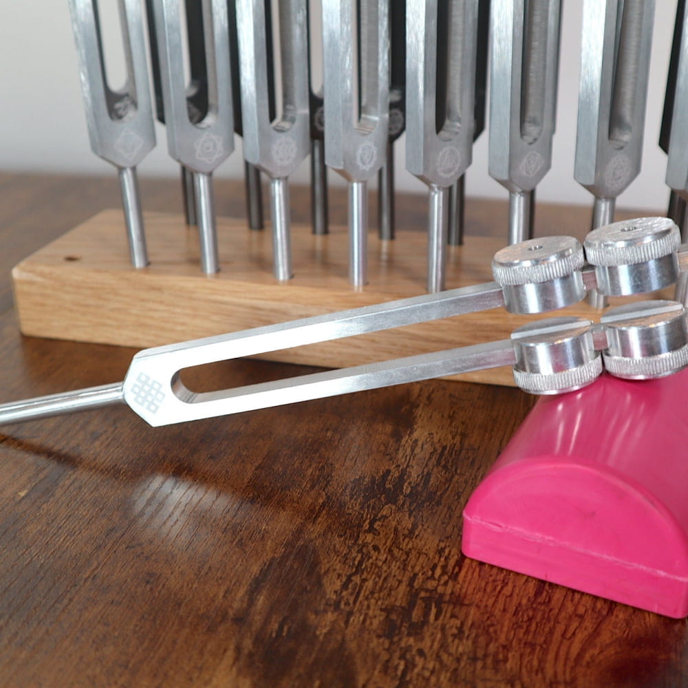 Tuning fork with weighted tips next to other forks in 18pc Tuning Fork Set