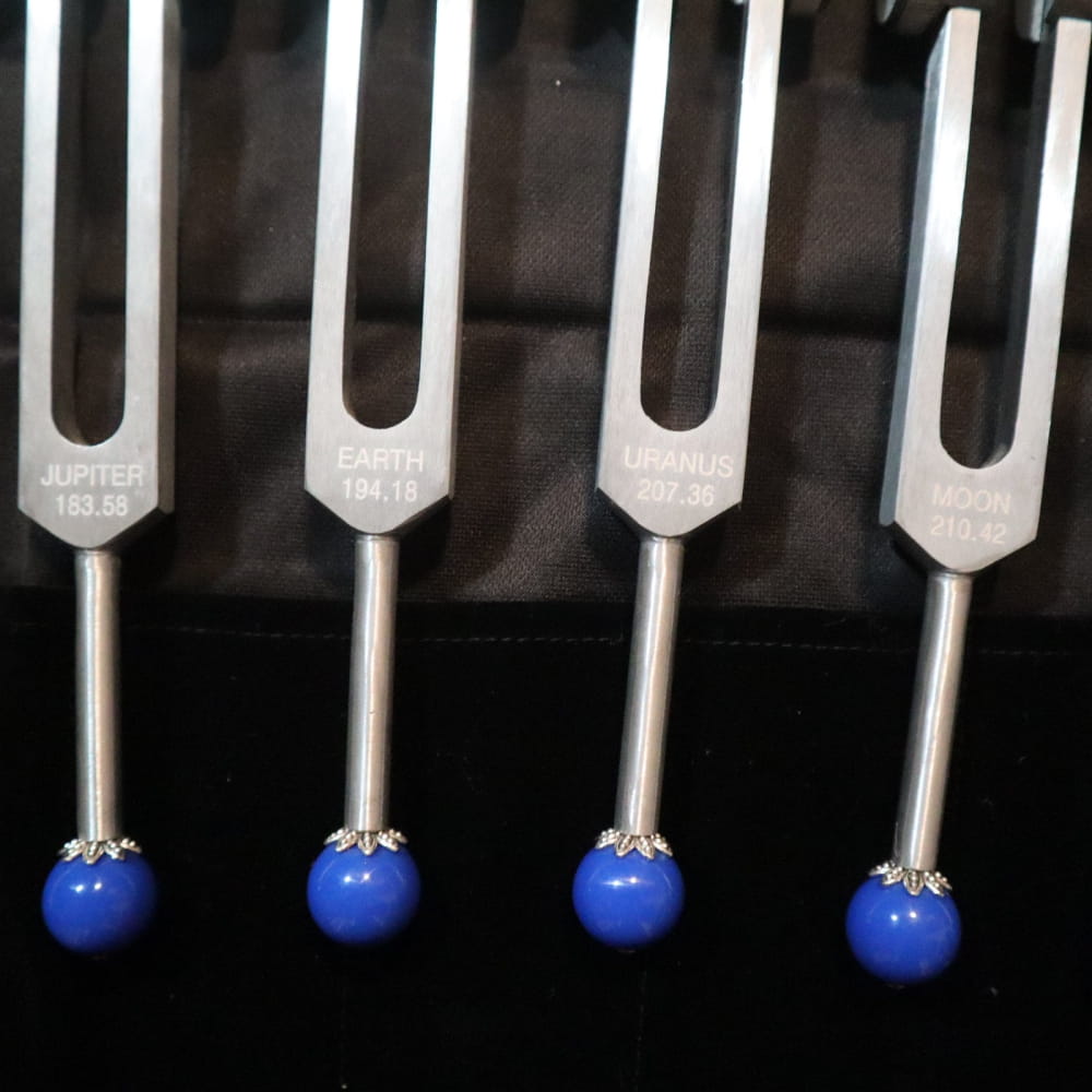 Four blue-ended tuning forks in a row from 19pc Chakra & Planetary Tuning Fork Set