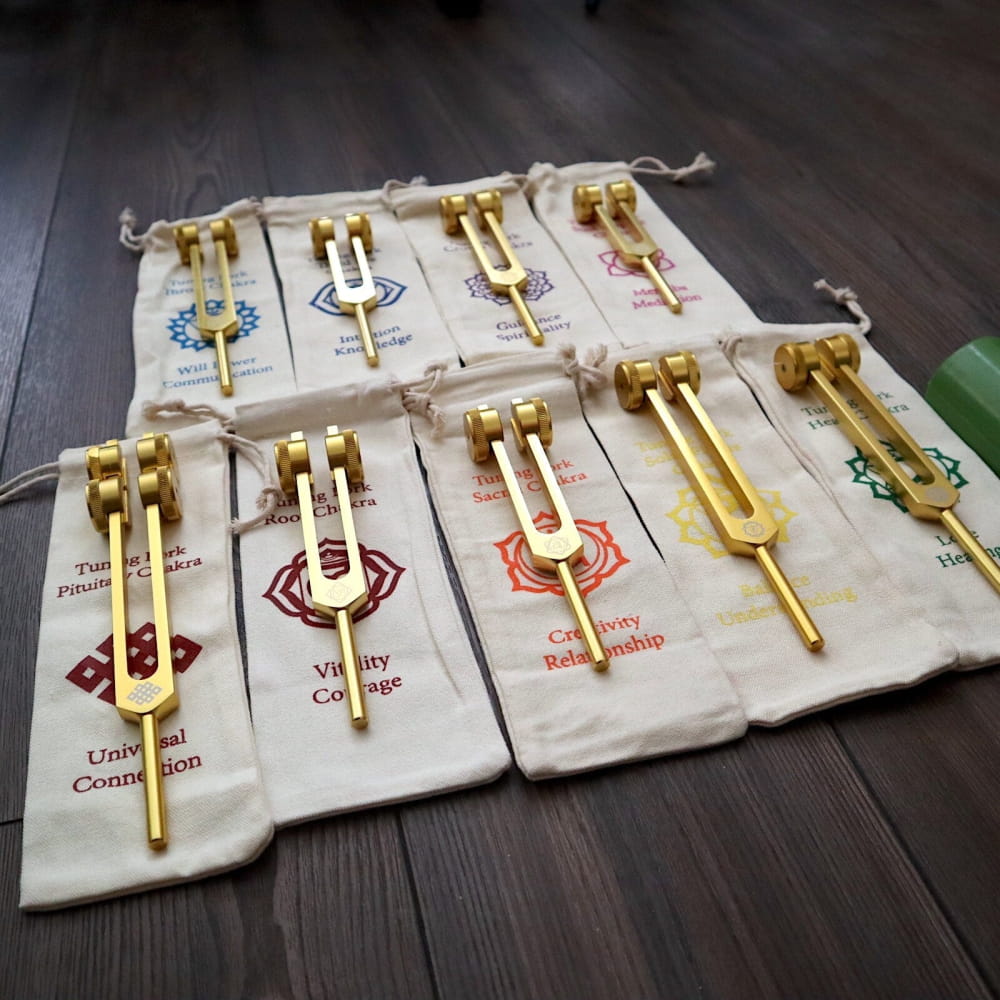 24K Gold 8pc Chakra Tuning Fork Set in pouches with decorative emblems for healing