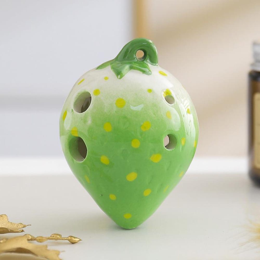Green ceramic strawberry ocarina pendant with yellow polka dots and decorative holes