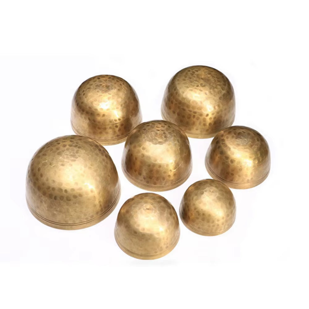 Seven brass hemispheres in a cluster, part of the 7-Piece Tibetan Singing Bowl Set
