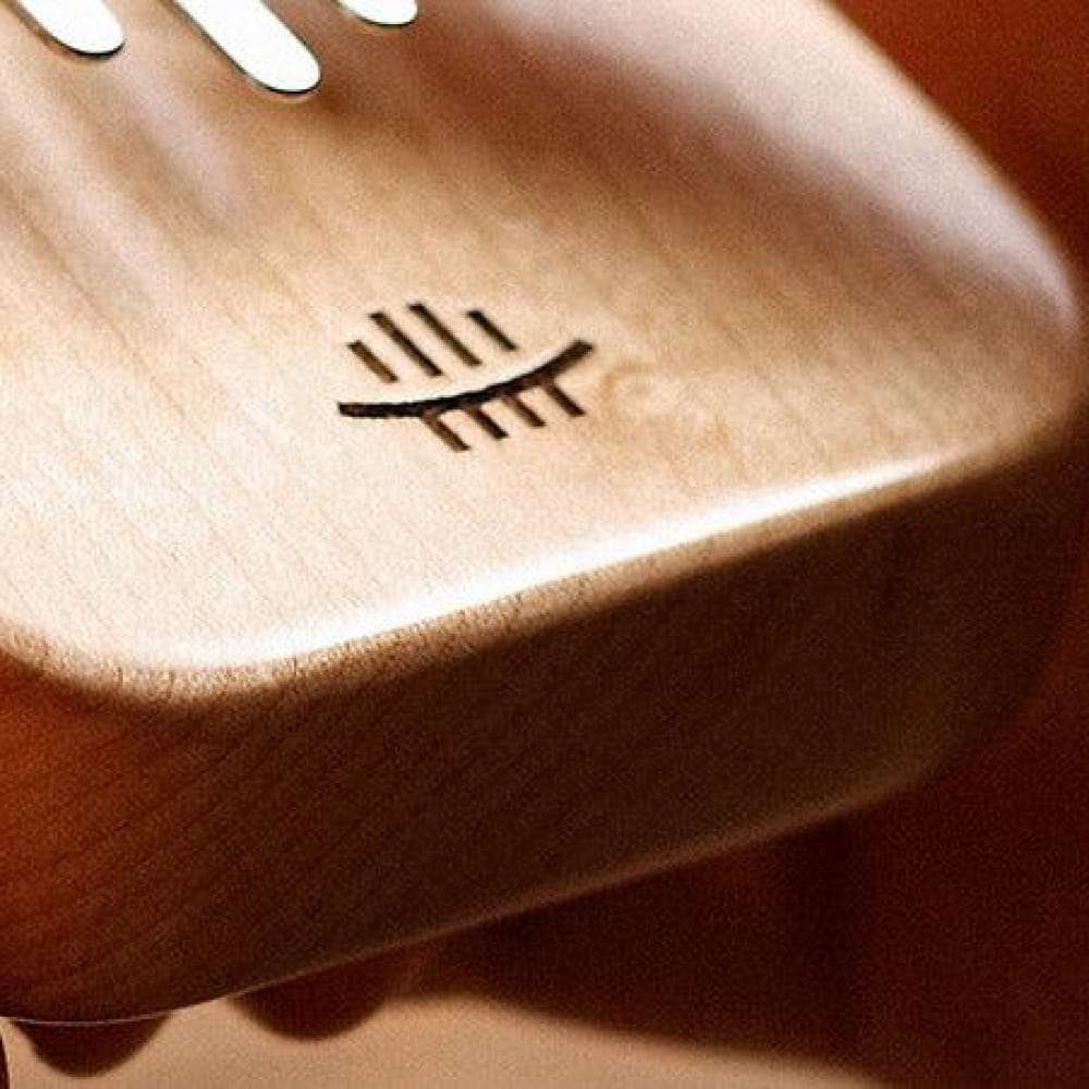 Metal fork with eye symbol on handle, shown with 8 Key Maple C Tone Kalimba