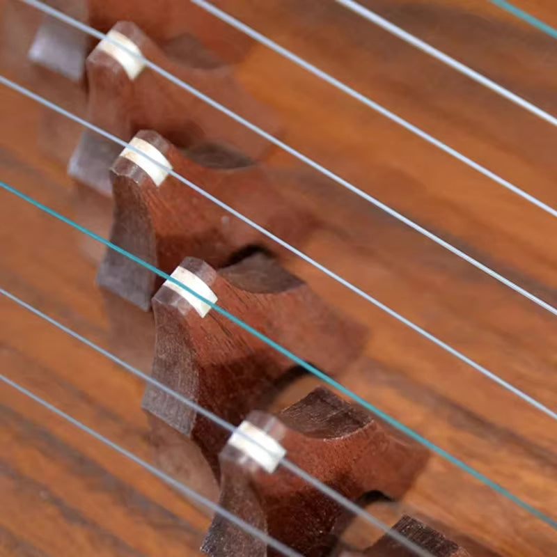 Guitar bridge with metal strings on polished wood of 82 cm Guzheng Chinese Zither