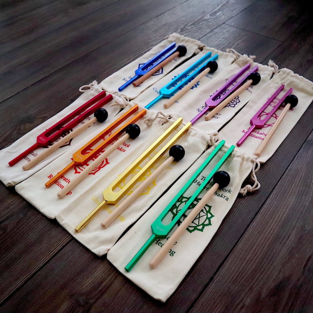 Colorful metal chopsticks in fabric sleeves arranged for 8pc Chakra Tuning Fork Set