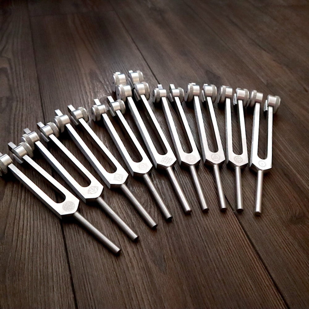 Collection of tuning forks in a curved line for chakra healing and sound therapy