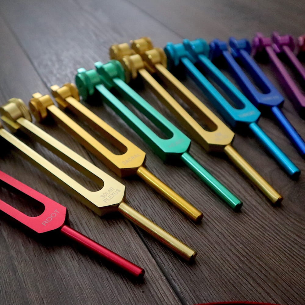 Colorful tuning forks in a row from the 9pc Chakra Tuning Fork Set for healing
