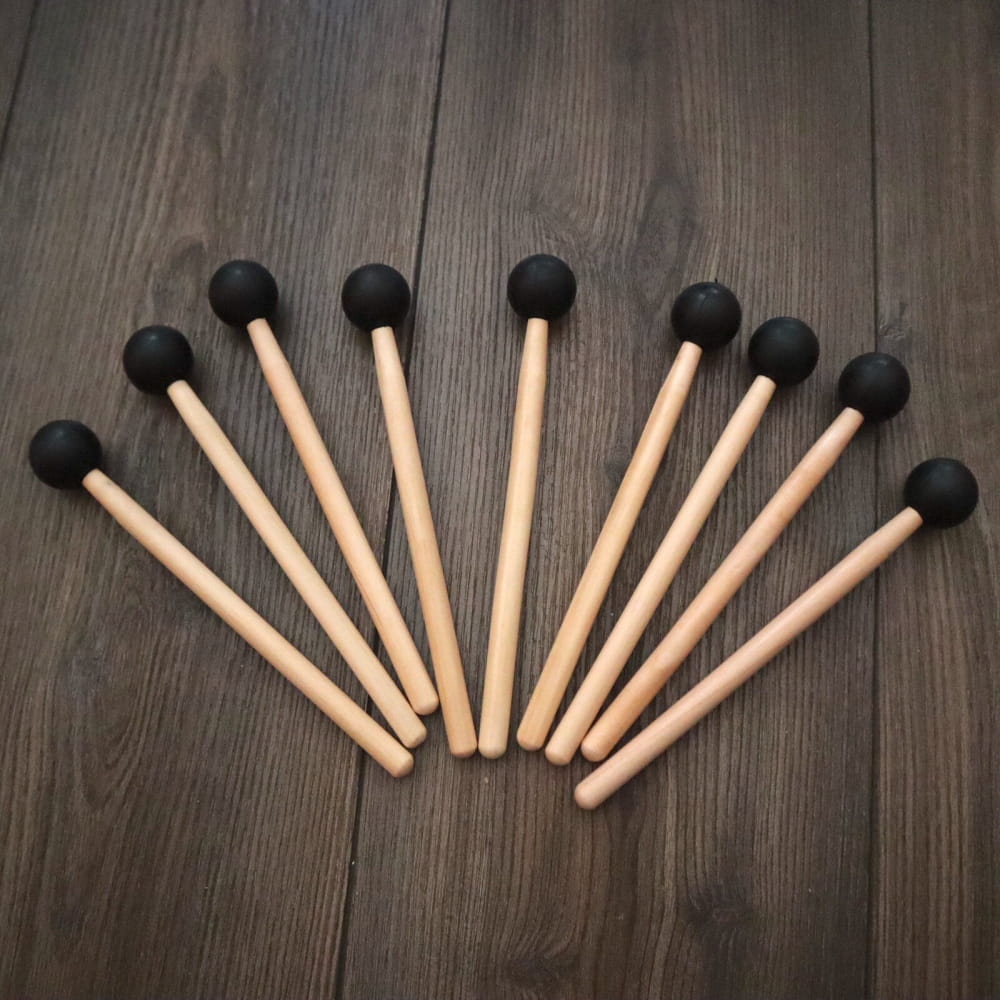 Eight wooden drumsticks with black rubber tips in a fan pattern for tuning fork set
