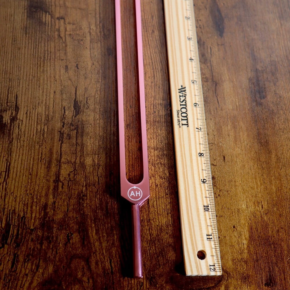 Solfeggio Tuning Fork Set with tuning fork and wooden ruler on a surface