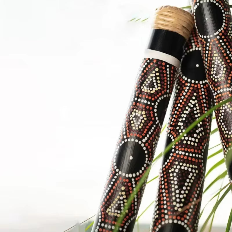 Decorative Aboriginal didgeridoos with traditional dot painting patterns in red, black, and white