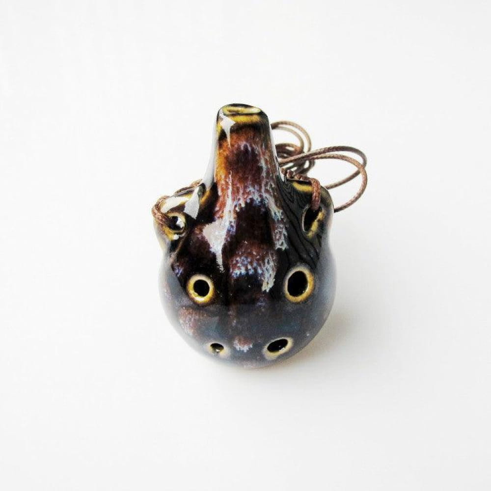 Dark ceramic ocarina pendant with yellow accents and six finger holes for beginners
