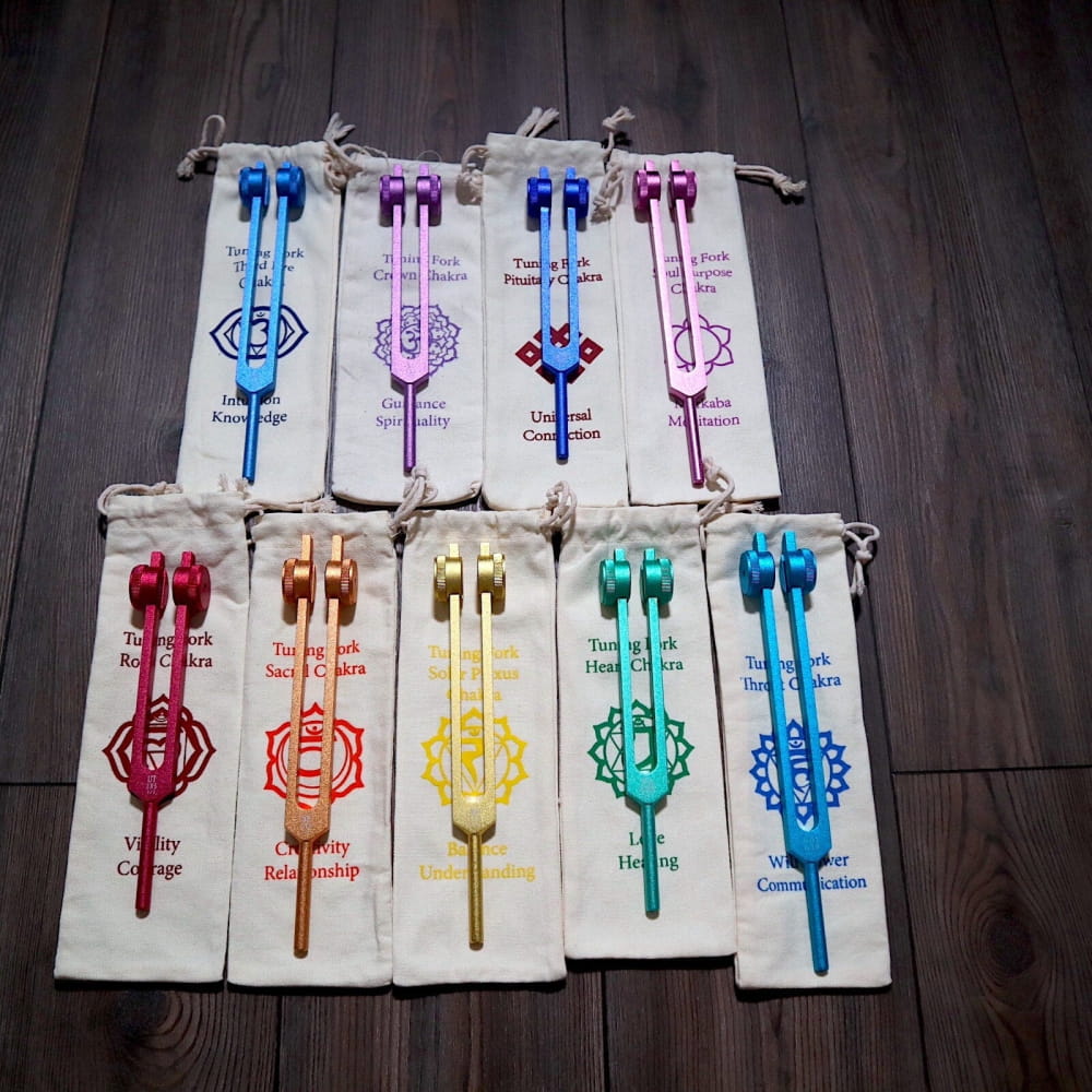 Colorful chakra wands on fabric pouches with chakra symbols for holistic healing