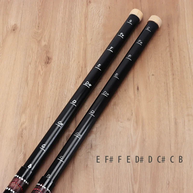 Two black bamboo flutes with finger holes and musical notes for sound healing