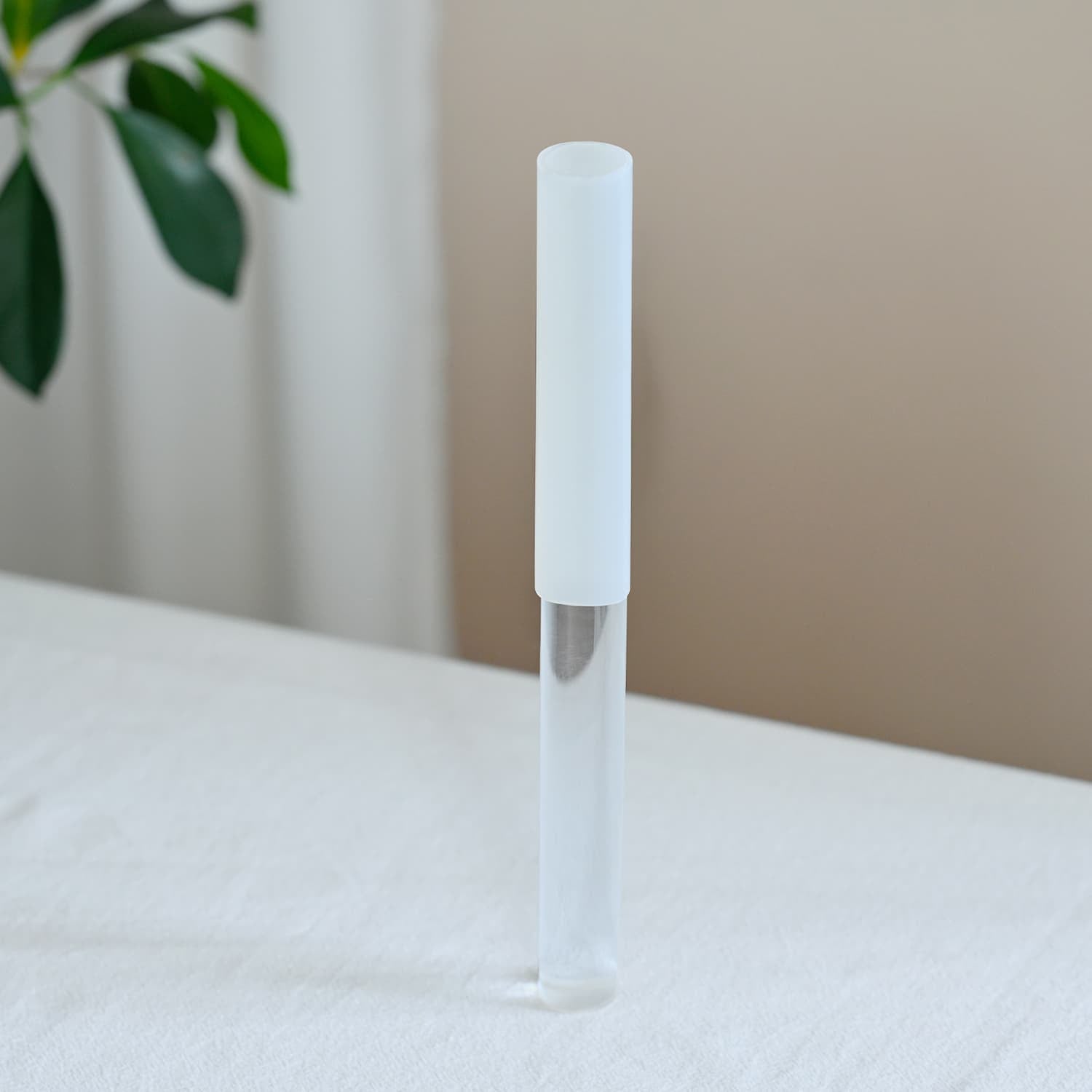 White minimalist cylindrical pen next to Half-Coated Crystal Singing Bowl Silicone Mallet