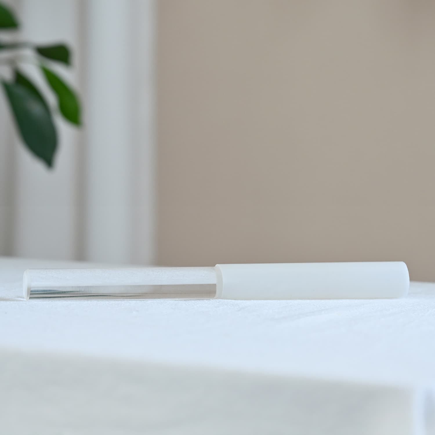 White pen resting on paper next to Half-Coated Crystal Singing Bowl Silicone Mallet