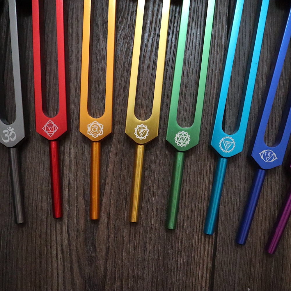 Colorful tuning forks with chakra symbols in rainbow order for healing and meditation