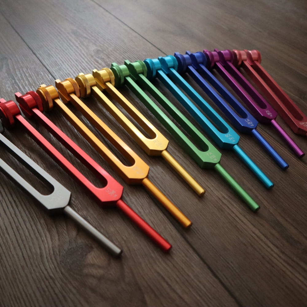 Rainbow-colored tuning forks in a row from the Professionally Tuned Solfeggio Forks set
