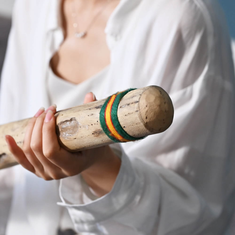 Champagne cork with green and gold foil bands on a handcrafted rainstick for meditation