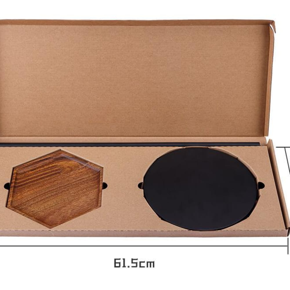 Open box displaying hexagonal wooden board and round black plate for Steel Tongue Drums