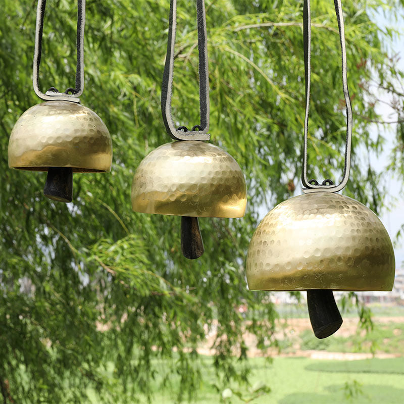 Three hanging brass bells with hammered domes on Tibetan Meditation Bell Instrument