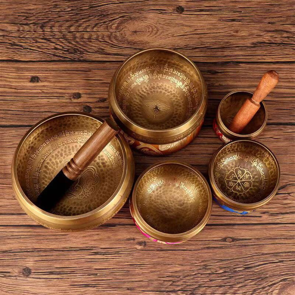Tibetan Singing Bowls with Wooden Strikers on Wooden Surface for Meditation Use